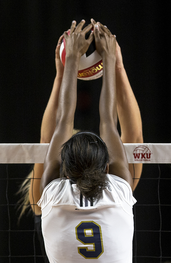 Florida International University sophomore middle blocker, Brianna Gogins, (9) attempts to block a hit by Western Kentucky University sophomore setter, Jessica Lucas, (1). The Lady Toppers defeated the Panthers in the first three sets. JAKE POPE