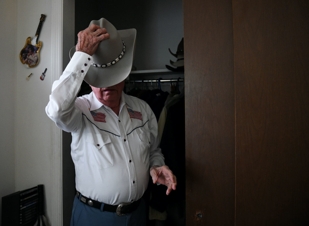 Topping of his look for a night of dancing at the Veterans of Foreign Wars Post #1493 in Frankfort, Kentucky, Arnold Clark, 87, puts on one of his several cowboy hats in his home on Friday, Oct. 23, 2015. NICHOLAS WAGNER