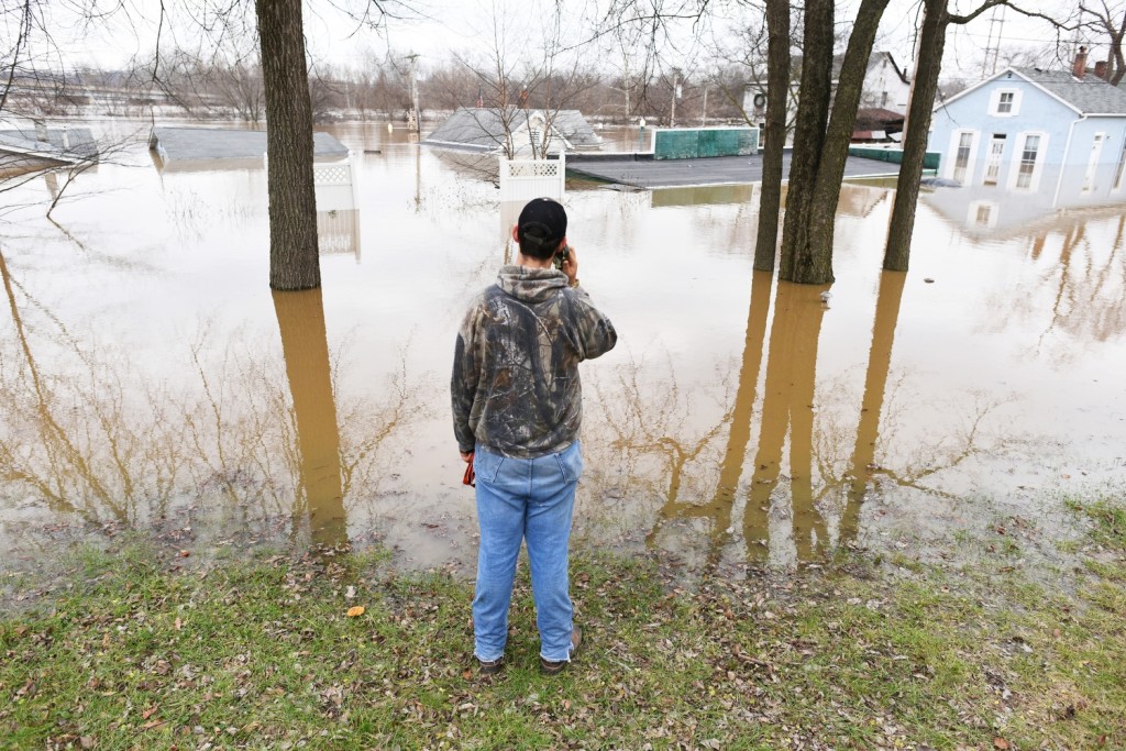 Dawson Newbold,16, of Housespring makes a call while taking a break from sandbagging on December 30, 2015 in Fenton, Missouri. The Meramec river is expected to crest at 43 ft late Wednesday. | Michael Noble Jr.