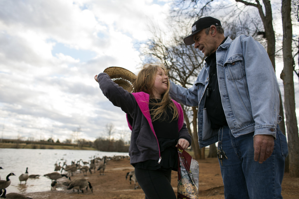 Ray "Raisin" Jones of Bowling Green helped his third cousin, Carleigh Frost of Bowling Green, 7, left, put her hat back on after it fell while she was feeding the ducks at Basil Griffin Park on Sunday, Jan. 31, 2016. Jones used to go to the same park with his own son, who is now 23. | Erica Lafser