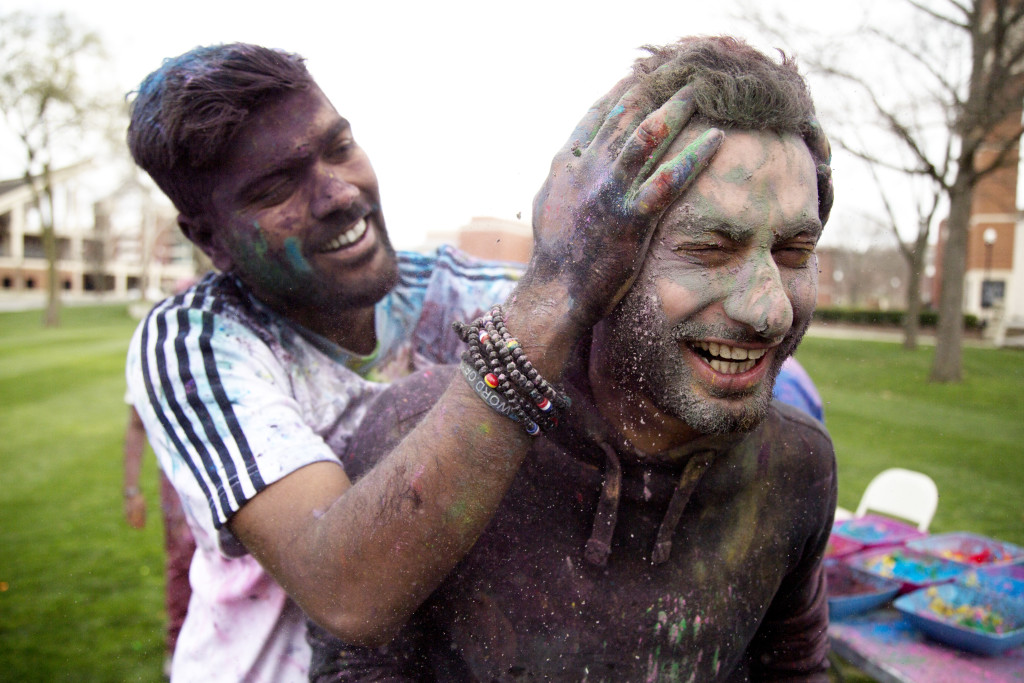 Chirag Ar, a sophomore from India, sneak attacks Saudi Arabian student, Mustafa Almarhun with handfuls of brightly colored holi powder during the 2016 Holi Festival hosted by the Indian Student Association on South Lawn at Western Kentucky University on March 19, 2016. Holi is a Hindu celebration of good over evil that is traditionally celebrated in India and southeast Asia. || Photo by Alyse Young