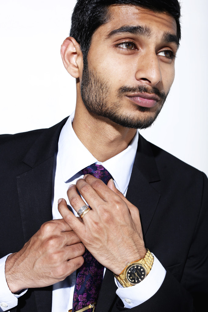 Rafey Wahlah models an Oyster Perpetual gold black faced Rolex Watch retailed at $12,550. The watch was a gift from his grandfather and matches the gold ring he wears from his grandmother that symbolizes eternal love.