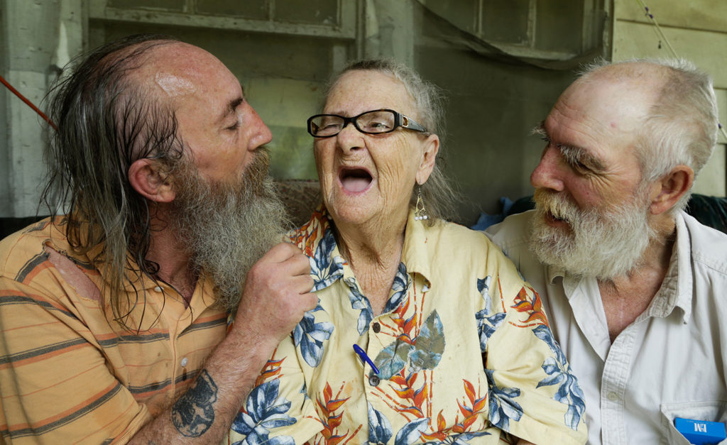 James Copas, 52 (left) and Harold Copas, 62 (right) sit on the front porch with their mother Mildred Walker, 89 as they enjoy the summer breeze and making their mother laugh. 23rd June 2016. Tompkinsville, Ky.