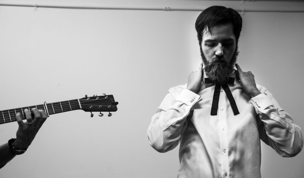 Derek Harris, the bass player for The Misty Mountain String Band, fixes his tie backstage before the start of the first Live Lost River Music Session at the Capitol Arts Center on Thursday, September 15th, 2016. This Lost River Music Session hosted a variety of folk-genres for a packed crowd, such as Bluegrass and Americana. || Photo by Weston Kenney